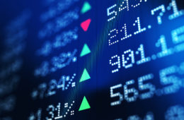 Financial data analysis graph showing stock market trends on a trading board. Horizontal composition with copy space and selective focus.